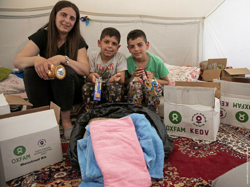 Mutter und ihre Söhne im Süden der Türkei mit Nahrungsmittel, warmen Decken und Hygienepaketen, die sie unmittelbar nach dem Erdbeben erhalten haben.