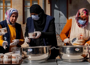 Drei Frauen die Lebensmittel an die Erdbebenopfer verteilen
