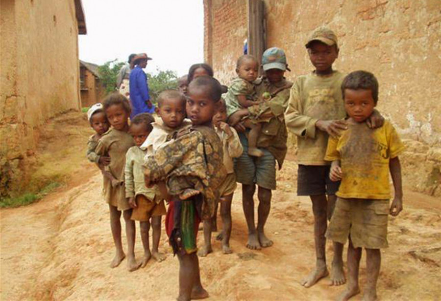 Gruppe von Kindern barfuß im Dorf, Ältere halten Jüngere im Arm