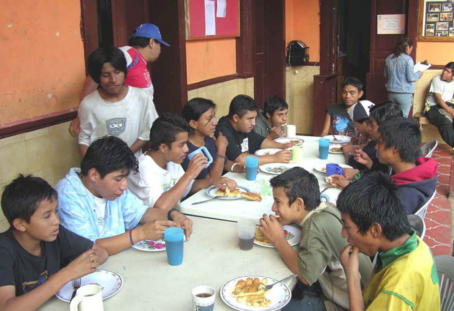 Mehrere obdachlose Jugendliche essen gemeinsam im Sozialzentrum