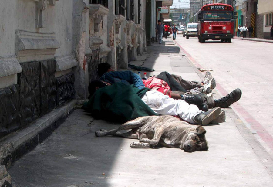 Obdachlose Jugendliche schlafen mit Hund auf dem Gehsteig