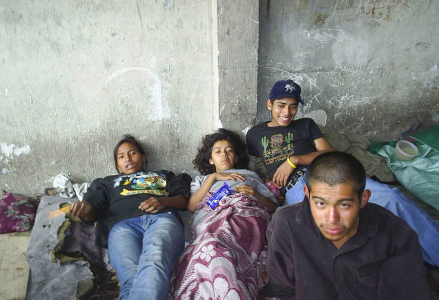 Obdachlose Jugendliche liegen auf Matratzen am Boden