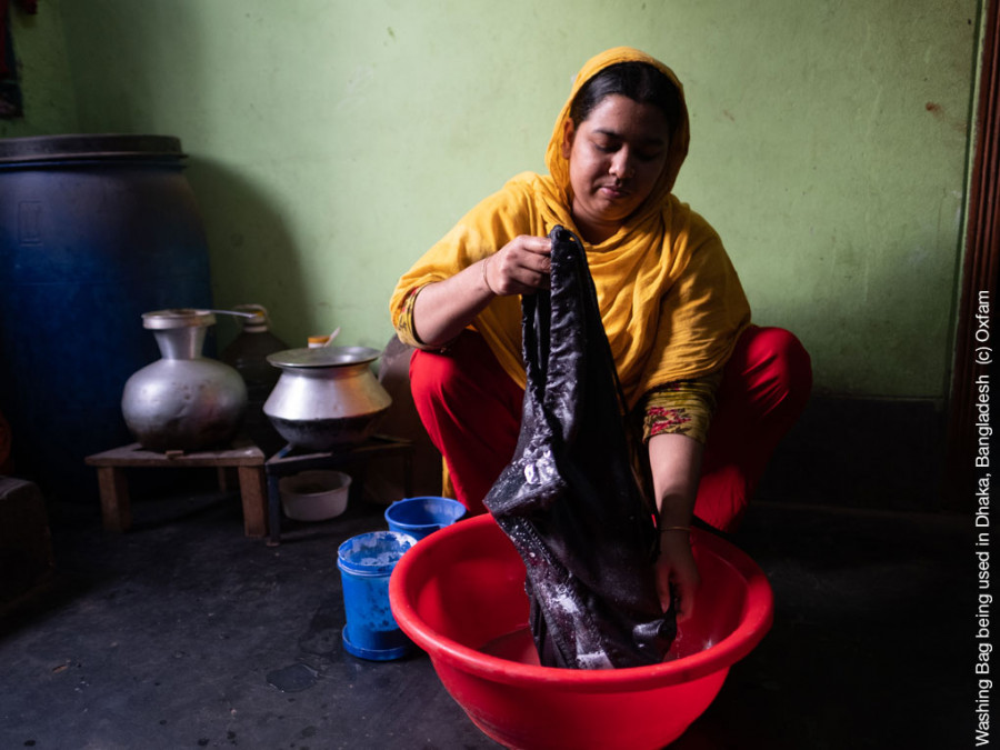 Eine Frau aus Bangladesch zeigt, wie man die Unterwäsche im Waschbeutel wäscht, die sie im Pilotprojekt unseres Projektes "Tage wie diese" erhalten hat.