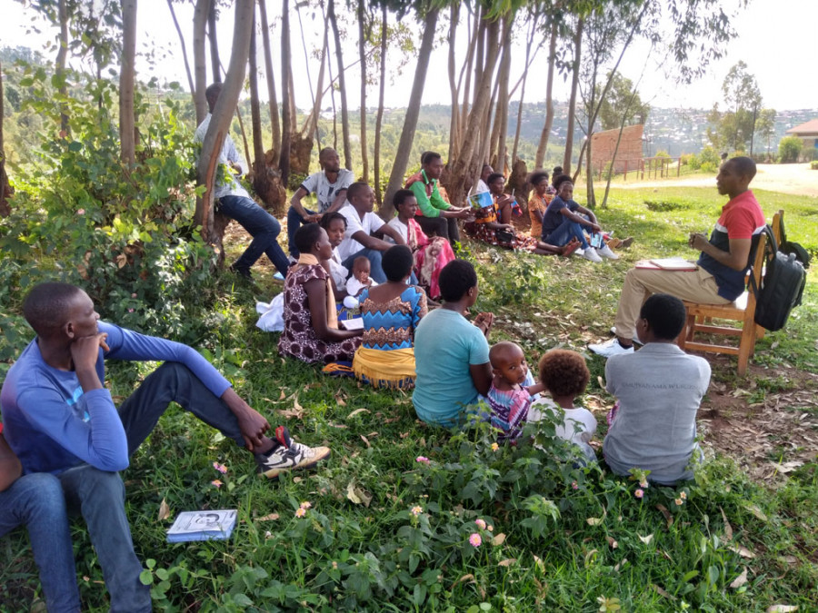 Menschen in Ruanda sitzen im Kreis bei einer Konfliktlösungsversammlung für Überlebende des Genozids an den Tutsi