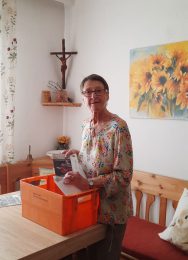 Frau mit Postversandbox und Aussendungsmaterial