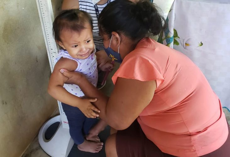 Indigene Gesundheitshelferin in Guatemala misst ein Kind ab