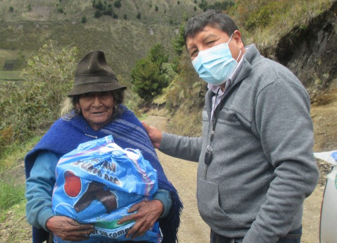 Indigene Frau die Lebensmittelpakte erhalten hat. Neben ihr Padre Eulogio
