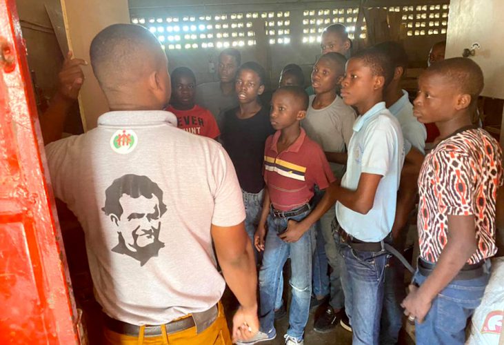 (c) Misereor Jugendliche und Kinder in Afrika hören einem Mann zu, der ihnen Information über eine handwerkliche Ausbildung gibt.