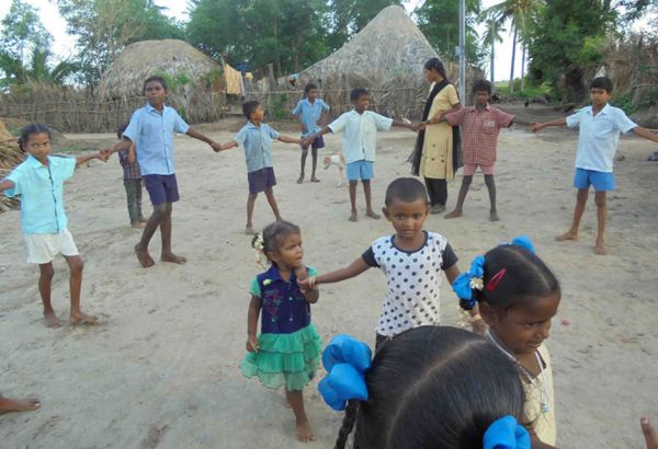 Neben der Lernbetreuung werden auch andere Freizeitaktivitäten organisiert, damit die Kinder für ein paar Stunden den schwierigen Alltag vergessen und einfach nur Kind sein können. Indische Kinder spielen barfuß im Halbkreis