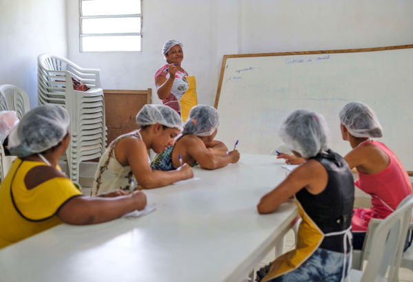 Im theoretischen Teil der Ausbildung werden Themen wie Lebensmittelhygiene, Haltbarmachung, effiziente Produktion und Betriebsführung behandelt. Frauen sitzen in einem Schulungsraum mit Tafel