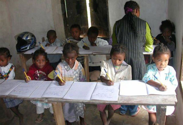 Die Eltern wünschen sich Schulbildung für ihre Kinder. Im Haus einer Familie wird ein Raum mit selbst gezimmerten Möbeln als Schulklasse eingerichtet. Kinder machen mit Lehrer Aufgaben im Unterrichtsraum