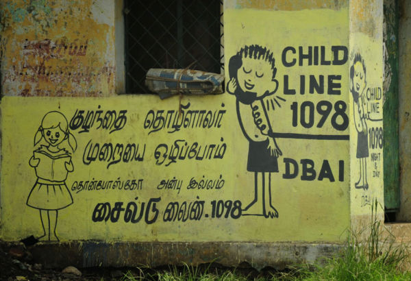 Wenn Straßenkinder Probleme haben und Hilfe benötigen, können sie bei der Telefonnothilfe Child Line anrufen. Die Mitarbeiter von DBAI leiten sie dann direkt in die Betreuungszentren weiter. Bemalte Mauer mit telefonierendem Kind wirbt für Kindertelefonnothilfe