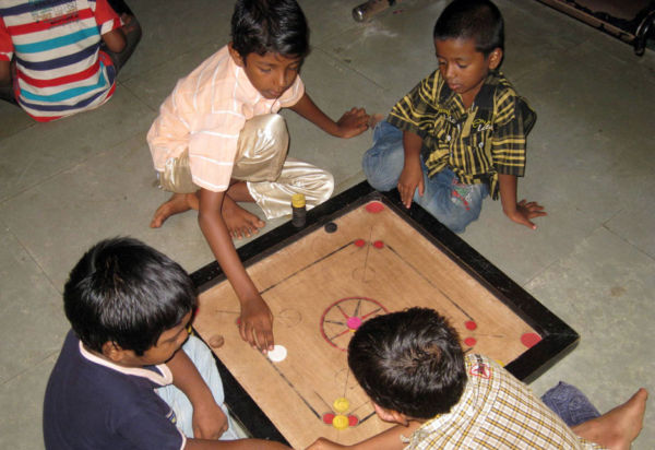 Gemeinsames spielen lässt die Sorgen
in den Hintergrund treten. Die Kinder können endlich Kind sein. Jungen spielen zusammen ein Brettspiel