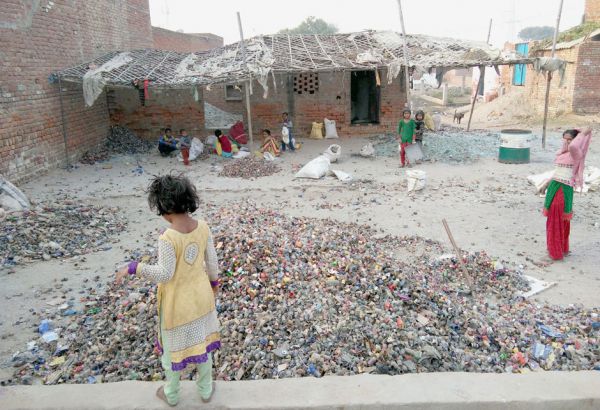 Mütter und Kinder bei der Arbeit:
Auf dem Gelände eines Glashändlers sortieren, reinigen und zerkleinern sie Fläschchen. Zehn bis zwölf Stunden am Tag. Für weniger als einen Euro Lohn. Schule, Sklaverei, Ausbildung, Indien, Asien, Kinder, Bildung, Rechte