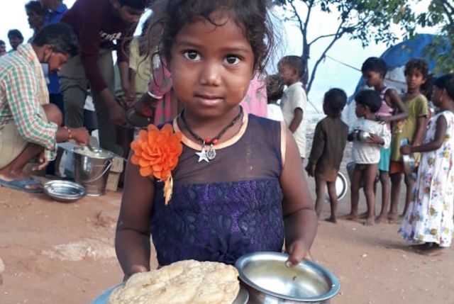 VRO verteilt Essen an ArbeiterInnen und deren Familien auf Müllplätzen außerhalb der Großstadt von Guntur in Andhra Pradesh. Indien, Asien, Hunger, Ernährung